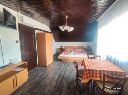a small room with a bed and a table and chairs at Viktória Panzió Zamárdi in Zamárdi