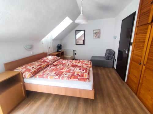 a bedroom with a bed and a chair in it at Viktória Panzió Zamárdi in Zamárdi