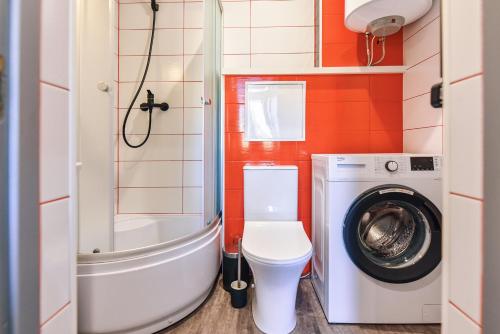 a small bathroom with a toilet and a washing machine at Dzintari in Ventspils