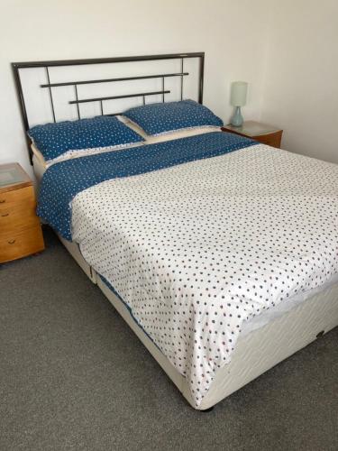 a bedroom with a large bed with blue and white sheets at HH Accommodation in Millom