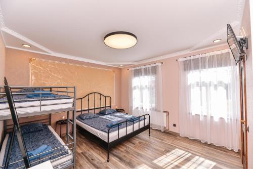 a room with two bunk beds and two windows at Dzintari in Ventspils