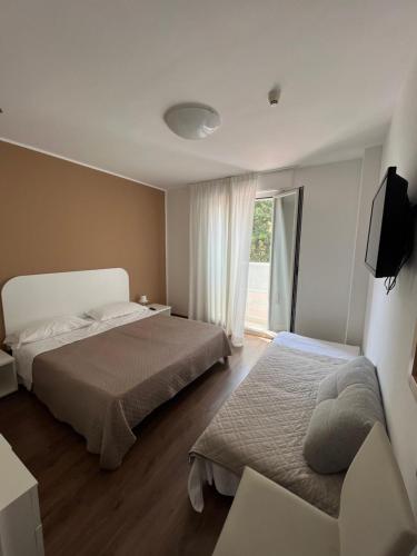 Habitación de hotel con 2 camas y ventana en Hotel Playa, en Bibione
