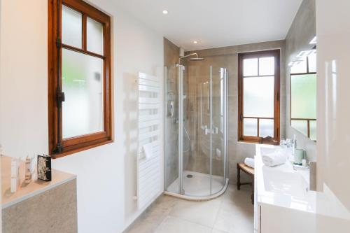 uma casa de banho com um chuveiro e um lavatório. em La Villa des Grillons, outstanding lake view and private garden - LLA Selections by Location Lac Annecy em Veyrier-du-Lac