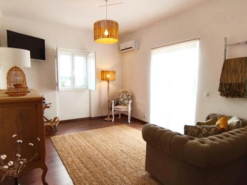 ein Wohnzimmer mit einem Sofa und einem Fenster in der Unterkunft Alecrim d'Aldeia in Fronteira
