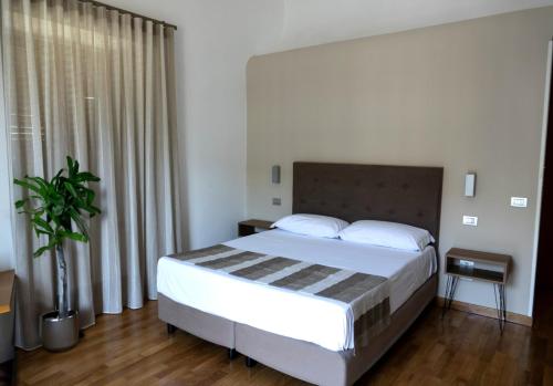 una camera con letto e pianta in vaso di Lungomare Suite & Spa a Napoli