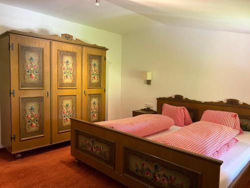 a bedroom with two beds and a wooden cabinet at Haus Schmetterling in Alpbach