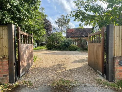Cottage 7 mins from Henley with gated parking في هينلي على نهر التايمز: مدخل لبيت مع بوابة خشبية