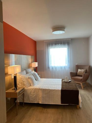 une chambre avec un lit, une chaise et une fenêtre dans l'établissement Zenao Appartements Le Cannet, au Cannet