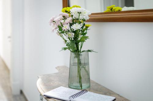 un vase de fleurs sur une table à côté d'un clavier dans l'établissement Casa Ella, à Olhão