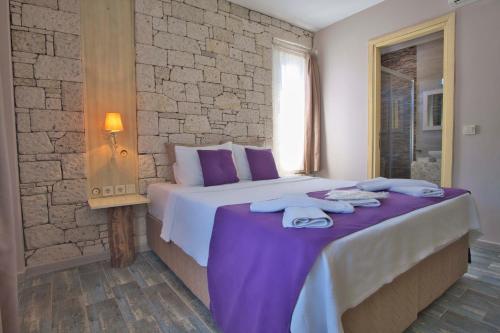 une chambre avec un grand lit avec des serviettes dessus dans l'établissement İonic Alaçatı, à Çeşme