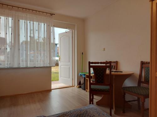 a living room with a door and a table and chairs at Pokoje Gościnne Tomasz in Międzywodzie