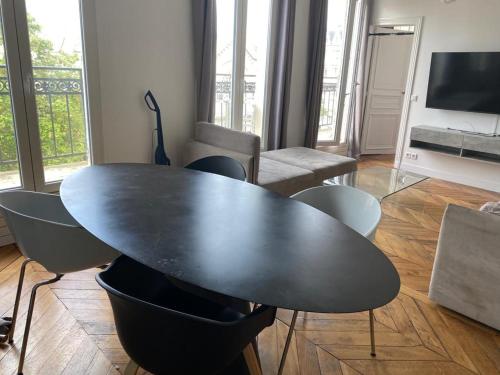 a black table and chairs in a living room at Bel appartement Montparnasse 70m2 in Paris