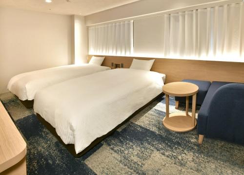 a bedroom with two beds and a blue couch at Nagoya Sakae Washington Hotel Plaza in Nagoya