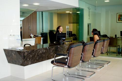 two women sitting at a reception desk in a lobby at Hotel Meridional in Fortaleza