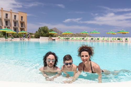 three people in a swimming pool at a resort at Villa Zina Family Resort in Custonaci