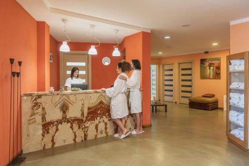 two women standing at a counter in a room at Villa Zina Family Resort in Custonaci
