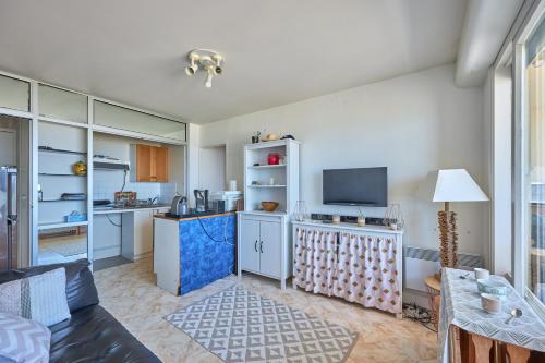 une pièce avec une cuisine et un salon dans l'établissement La Longue Vue - Appt face à la mer, à Courseulles-sur-Mer