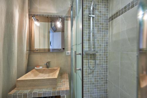 une salle de bain avec un lavabo et une douche dans l'établissement La Longue Vue - Appt face à la mer, à Courseulles-sur-Mer