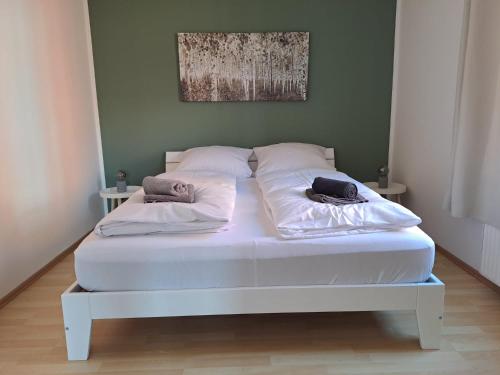 un letto bianco con due cuscini sopra di Ferienwohnung Auszeit a Rostock