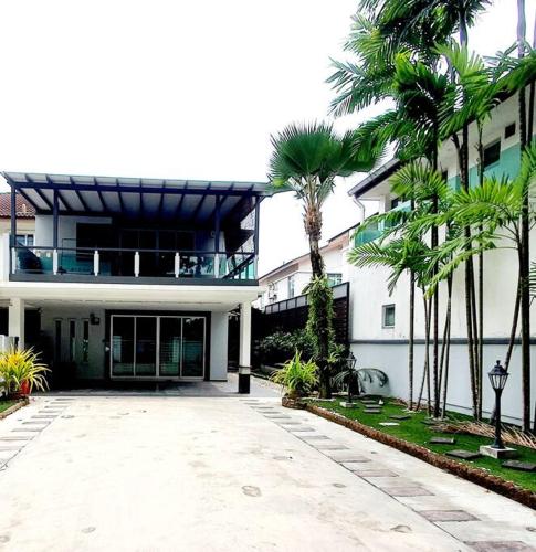 a large white building with palm trees in front of it at GARDEN COZY2STOREY HOME 4ROOM 10PAX@NEAR ALMAJUSCO in Bukit Mertajam