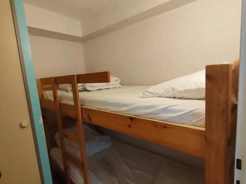 une chambre avec un lit superposé avec des draps blancs dans l'établissement Appartement T2 bis avec cour, proche télécabine et commerces - Cauterets, 6 couchages - FR-1-234-127, à Cauterets