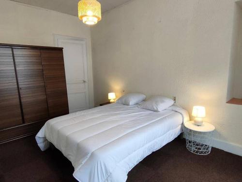 une chambre avec un grand lit blanc avec deux lampes dans l'établissement Appartement 2 pièces central à Cauterets avec balcon, parking et proximité Citycab - FR-1-234-145, à Cauterets