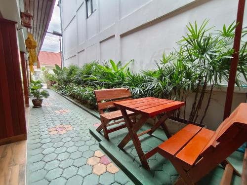 a wooden table and chairs sitting next to a building at Aphilapa Residence in Chiang Mai