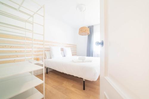 una camera con un letto bianco e una parete di vetro di Casa A Bicuda a Ferrol