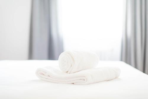 a stack of towels on a bed in front of a mirror at Casa A Bicuda in Ferrol