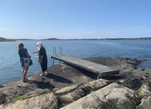 two women standing on the rocks near a dock at Hamnhuset Björkö in Björkö