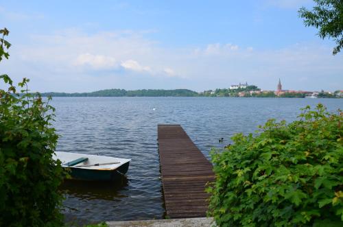 a boat is docked at a dock on a lake at Ferienwohnungen Himmelsstübchen und Gartenstübchen in Plön