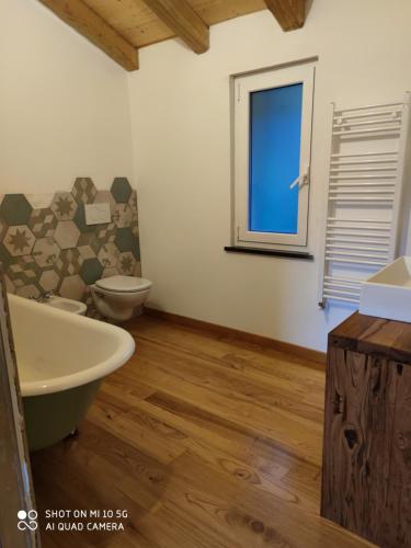 baño con lavabo y aseo y ventana en La Pezzuola 53, en Sopralacroce