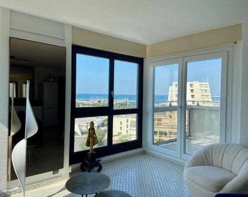 una sala de estar con una gran ventana con vistas al océano en Le Mousse, P2 cosy avec une magnifique vue mer, parking, en La Grande-Motte