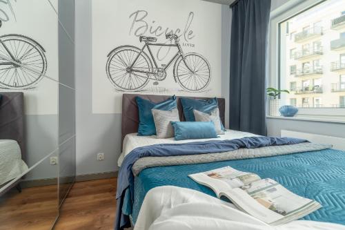 a bedroom with a bed with a bike on the wall at Margi Soho Apartament in Szczecin