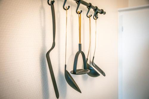 Quatre ustensiles de cuisine sont suspendus sur un mur dans l'établissement Blue Gold - Saint Rémi - Basilique, à Reims