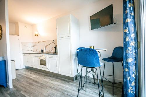 - une cuisine avec deux tabourets et une table dans une pièce dans l'établissement Blue Gold - Saint Rémi - Basilique, à Reims