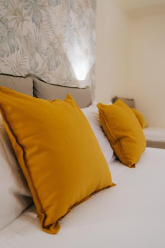 a bed with yellow pillows on top of it at Il Meraviglioso Mondo di Amélie in Agrigento