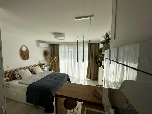 una camera da letto con un letto, un tavolo e una finestra di La Riva Mia Spa Dziwnów a Dziwnów