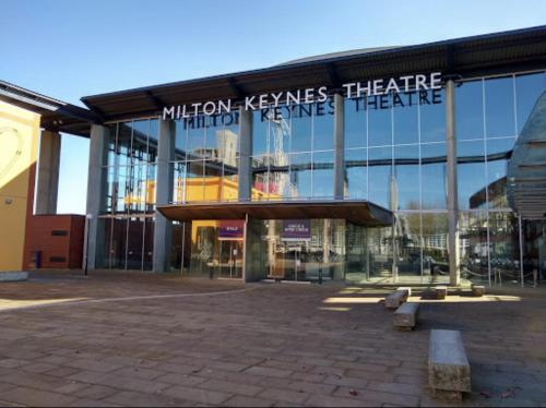 a building with a sign that reads million keeps healthcare third needles theatre at Campbell Park apartment with a balcony and free parking in Milton Keynes