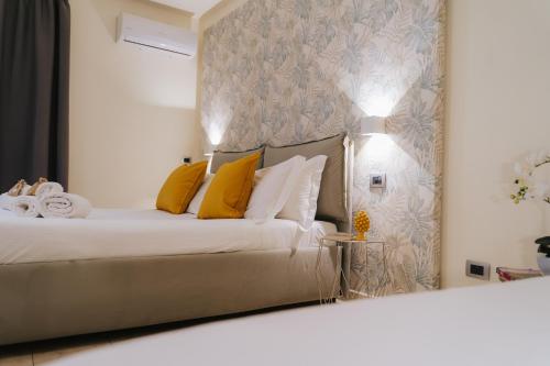 a bedroom with a white bed with yellow pillows at Il Meraviglioso Mondo di Amélie in Agrigento