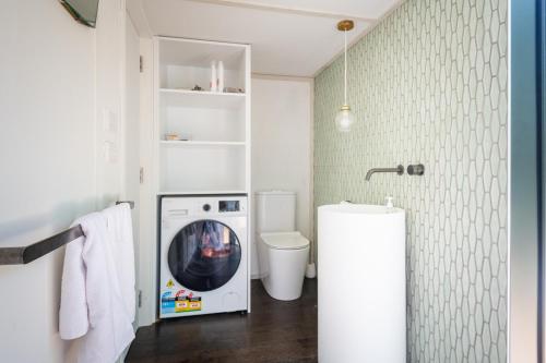 a laundry room with a washer and dryer in it at The Urban Tramping Hut in Rotorua