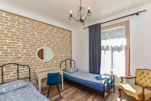 een slaapkamer met 2 bedden en een bakstenen muur bij VILLA KURLAND in Ventspils