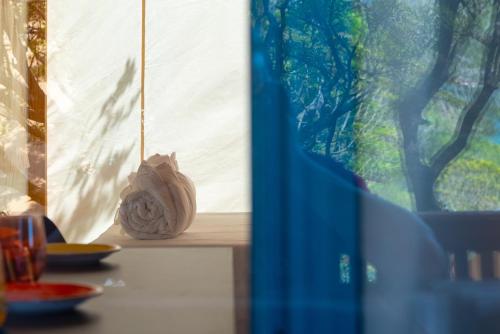 a vase sitting on a table next to a window at Camping Lacona Pineta in Capoliveri