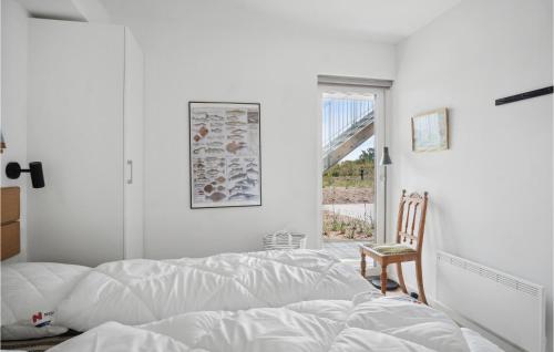 um quarto com uma cama, uma cadeira e uma janela em Havnehusene, Lejl, 29 em Slagelse