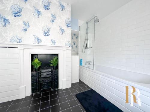 a bathroom with a fireplace with blue and white wallpaper at Fisherman's Cottage - Harwich Breaks - BRAND NEW - long stays available great prices - get in touch for all bookings - cottage in harwich - beach stay in Harwich