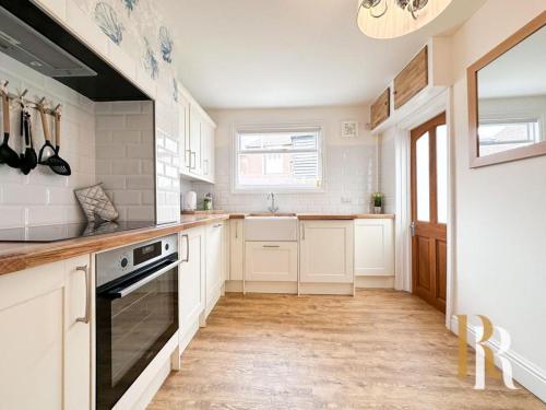 a kitchen with white cabinets and a stove top oven at Fisherman's Cottage - Harwich Breaks - BRAND NEW - long stays available great prices - get in touch for all bookings - cottage in harwich - beach stay in Harwich
