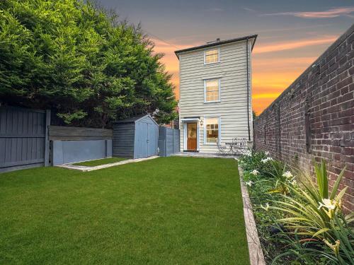 a house with a yard with a brick wall at Fisherman's Cottage - Harwich Breaks - BRAND NEW - long stays available great prices - get in touch for all bookings - cottage in harwich - beach stay in Harwich