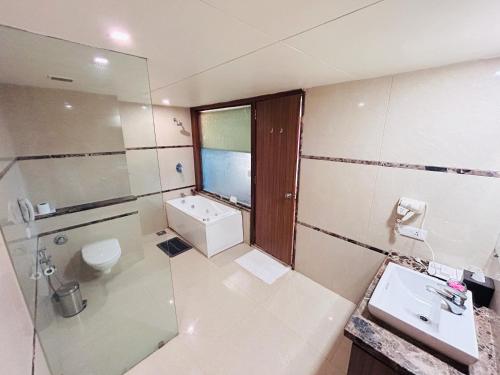 a bathroom with a sink and a toilet and a shower at Boulevard 9 Luxury Resort & Spa in Nadiād