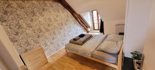 une chambre avec un lit et un mur dans l'établissement Agréable Gîte proche du ZOO de Beauval et des chateaux3, à Selles-sur-Cher
