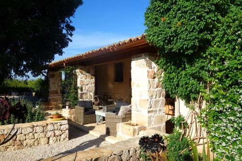 a stone house with a stone wall at Casa di Melo - Organic Country Hotel in Cassibile